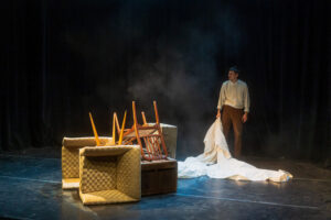 Homme seul sur scène avec meubles renversés