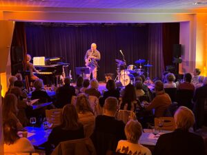 Homme seul sur scène avec saxophone devant un public assis